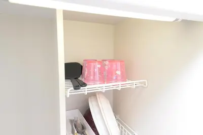 a shelf in a closet with pink items on it at \u548c\u306e\u6953cottage\u7b2c\u4e8c302 \u65b0\u5bbf\u6b4c\u821e\u4f0e\u753a\u8fd1\u96a3 in Tokyo
