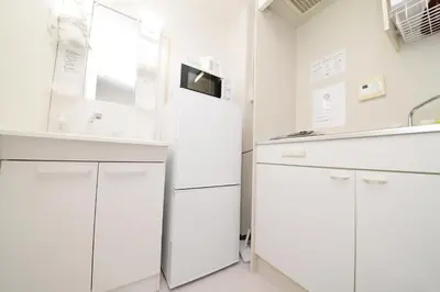 a kitchen with white cabinets and a refrigerator at \u548c\u306e\u6953cottage\u7b2c\u4e8c302 \u65b0\u5bbf\u6b4c\u821e\u4f0e\u753a\u8fd1\u96a3 in Tokyo
