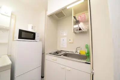 a small kitchen with a sink and a refrigerator at \u548c\u306e\u6953cottage\u7b2c\u4e8c302 \u65b0\u5bbf\u6b4c\u821e\u4f0e\u753a\u8fd1\u96a3 in Tokyo