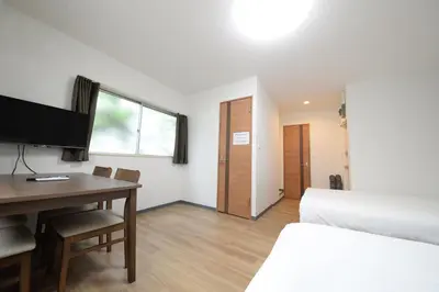 a hotel room with a desk and a bed and a bedroom at \u548c\u306e\u6953cottage\u7b2c\u4e8c302 \u65b0\u5bbf\u6b4c\u821e\u4f0e\u753a\u8fd1\u96a3 in Tokyo