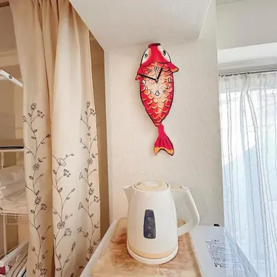 a red fish hanging on a wall next to a kettle at Lucky House\u65b0\u5bbf22 in Tokyo