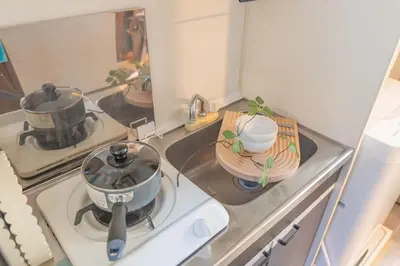 a kitchen with a stove with two pots on it at Lucky House\u65b0\u5bbf22 in Tokyo