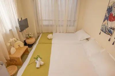 a small room with two beds and a tv at Lucky House\u65b0\u5bbf22 in Tokyo