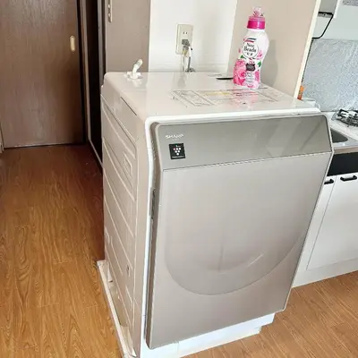 a washing machine with a bottle of water on top of it at Lucky House\u65b0\u5bbf31 in Tokyo