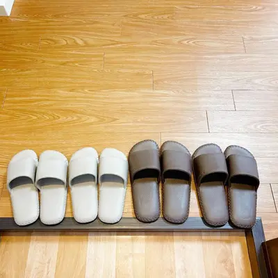 a row of five pairs of shoes on a shelf at Lucky House\u65b0\u5bbf31 in Tokyo