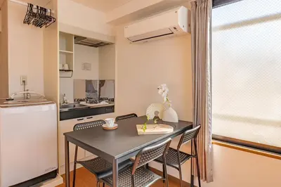 a small kitchen with a black table and chairs at Lucky House\u65b0\u5bbf31 in Tokyo