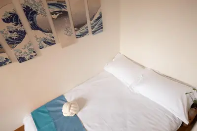 a white bed with a stuffed animal on top of it at Lucky House\u65b0\u5bbf31 in Tokyo