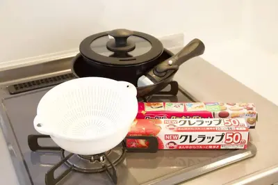 a pot and a white fan on a stove with books at \u30d3\u30b9\u30bf\u6c60\u4e0a 301 in Tokyo