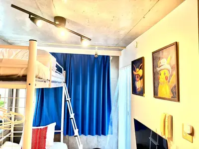 a bedroom with a bunk bed and a blue curtain at \u65b0\u5bbf\u307e\u30671\u99c5 \u521d\u53f0\u99c5\u5f92\u6b699\u5206 \u30b3\u30f3\u30d3\u30cb2\u5206 PokeMon\u3068\u66ae\u3089\u3059\u30c7\u30b6\u30a4\u30ca\u30fc\u30ba\u30eb\u30fc\u30e0 in Tokyo