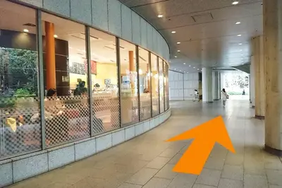 an orange arrow is pointing into a building at \u65b0\u5bbf\u307e\u30671\u99c5 \u521d\u53f0\u99c5\u5f92\u6b699\u5206 \u30b3\u30f3\u30d3\u30cb2\u5206 PokeMon\u3068\u66ae\u3089\u3059\u30c7\u30b6\u30a4\u30ca\u30fc\u30ba\u30eb\u30fc\u30e0 in Tokyo