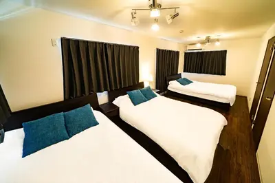 a bedroom with two beds and two windows at 29, Omori-kita, Private house rental, \u5927\u68ee\u5317 in Tokyo