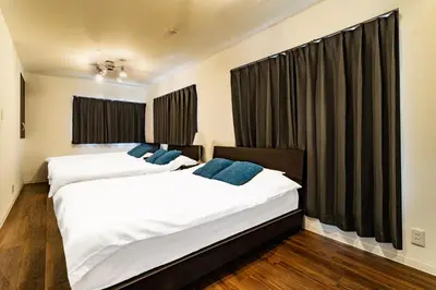 two beds in a room with black curtains at 29, Omori-kita, Private house rental, \u5927\u68ee\u5317 in Tokyo