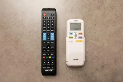 a remote control and a smart phone sitting on a table at Ferio\u84b2\u7530III in Tokyo