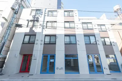 a white building with blue doors and windows at Ferio\u84b2\u7530III in Tokyo