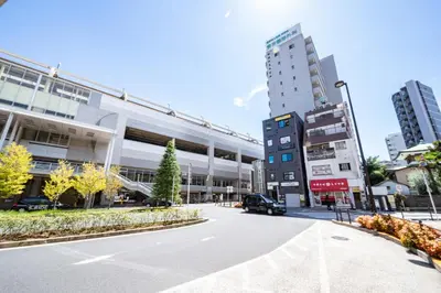 an empty street in a city with tall buildings at Ferio\u84b2\u7530III in Tokyo