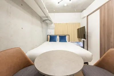 a bedroom with a bed and a table and chairs at Ferio\u84b2\u7530III in Tokyo