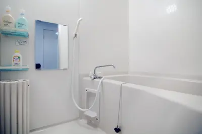a white bathroom with a shower and a sink at \u5927\u68ee\u30db\u30c6\u30eb \u30d3\u30c3\u30b0\u30d5\u30a9\u30ec\u30b9\u30c8 in Tokyo