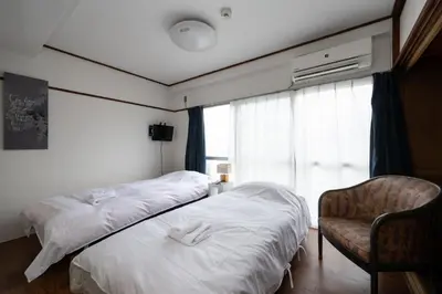 a hotel room with two beds and a chair at \u5927\u68ee\u30db\u30c6\u30eb \u30d3\u30c3\u30b0\u30d5\u30a9\u30ec\u30b9\u30c8 in Tokyo