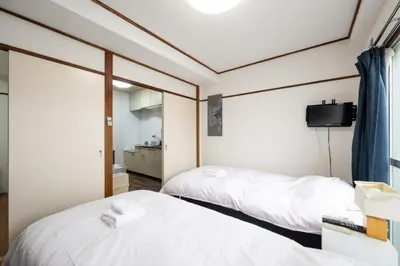 two beds in a room with a tv on the wall at \u5927\u68ee\u30db\u30c6\u30eb \u30d3\u30c3\u30b0\u30d5\u30a9\u30ec\u30b9\u30c8 in Tokyo