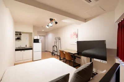 a living room with a table and a kitchen at \u65b0\u5bbf\u5ca1\u7530\u30d3\u30eb in Tokyo