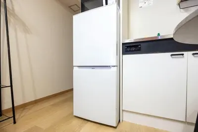 a white refrigerator in a room with white cabinets at \u65b0\u5bbf\u5ca1\u7530\u30d3\u30eb in Tokyo
