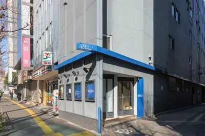 a building with a blue sign on the side of a street at \u65b0\u5bbf\u5ca1\u7530\u30d3\u30eb in Tokyo