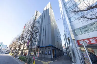a tall building on the side of a city street at \u65b0\u5bbf\u5ca1\u7530\u30d3\u30eb in Tokyo