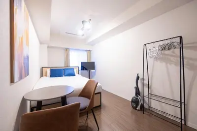 a bedroom with a bed and a table and chairs at \u65b0\u5bbf\u5ca1\u7530\u30d3\u30eb in Tokyo