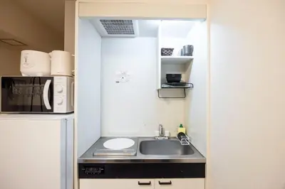 a small kitchen with a sink and a refrigerator at \u65b0\u5bbf\u5ca1\u7530\u30d3\u30eb in Tokyo