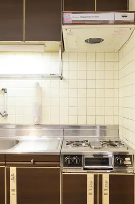 a kitchen with a stove and a sink at Shinjuku Kabukicho Harmony Inn in Tokyo