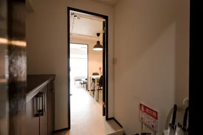 a hallway with a door leading to a dining room at Shinjuku Kabukicho Harmony Inn in Tokyo