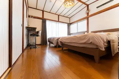 a bedroom with two beds and a wooden floor at Shinjuku , 3min walk Okubo Sta, net, PocketWi-Fi, Switch in Tokyo