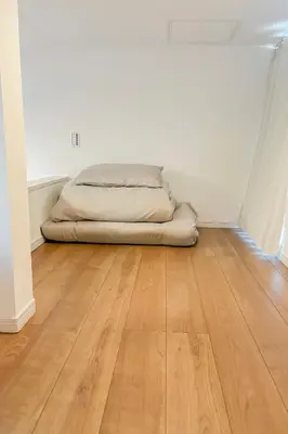 a bed in an empty room with a wooden floor at \u5bbf\u6816\u6e0b\u8c37 in Tokyo