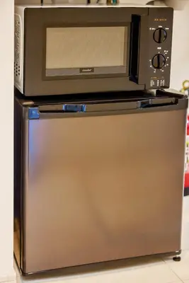 a microwave oven sitting on top of a refrigerator at \u5bbf\u6816\u6e0b\u8c37 in Tokyo