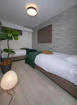 a bedroom with two beds and a potted plant at \u3077\u3075\u304b\u6771\u5411\u5cf62 in Tokyo