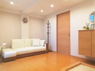 a living room with a white couch and a door at 3F\u6c60\u888b\u6700\u4e2d\u5fc3 \u4e24\u5ba4\u4e00\u5385 \u6c60\u888b\u7ad910\u5206 2 rooms Ikebukuro center 10 mins to ST Max 7P \u76f4\u8fbe\u65b0\u5bbf \u6d89\u8c37 \u8868\u53c2\u9053 \u6c60\u888b \u4e0a\u91ce \u4ee3\u4ee3\u6728 \u94f6\u5ea7 \u539f\u5bbf in Tokyo