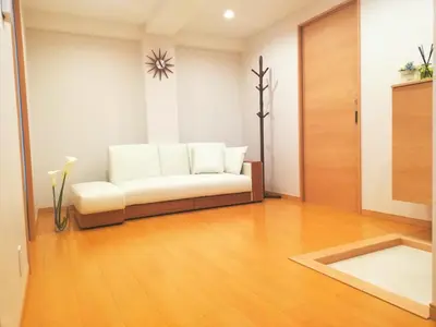 a living room with a white couch and a wooden floor at 3F\u6c60\u888b\u6700\u4e2d\u5fc3 \u4e24\u5ba4\u4e00\u5385 \u6c60\u888b\u7ad910\u5206 2 rooms Ikebukuro center 10 mins to ST Max 7P \u76f4\u8fbe\u65b0\u5bbf \u6d89\u8c37 \u8868\u53c2\u9053 \u6c60\u888b \u4e0a\u91ce \u4ee3\u4ee3\u6728 \u94f6\u5ea7 \u539f\u5bbf in Tokyo