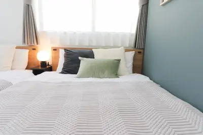 a large white bed with a green pillow on it at HOTEL Beruhigen Tokyo - Vacation STAY 93718v in Tokyo