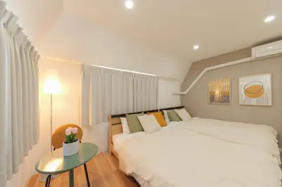 a bedroom with a bed and a table with a vase of flowers at HOTEL Beruhigen Tokyo - Vacation STAY 93718v in Tokyo