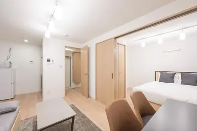 a bedroom with a bed and a living room at Mat\u91ce\u65b9 in Tokyo
