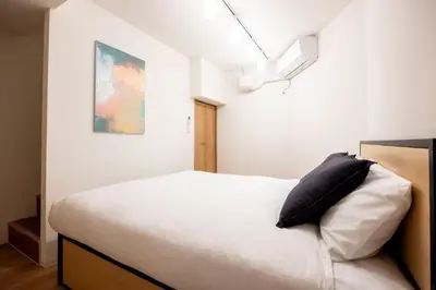 a bedroom with a white bed with a black pillow at Mat\u91ce\u65b9 in Tokyo