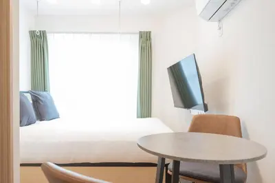 a room with a bed and a table and a tv at Mat\u91ce\u65b9 in Tokyo