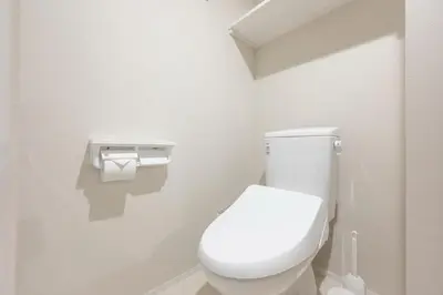 a white bathroom with a toilet and a roll of toilet paper at Mat\u91ce\u65b9 in Tokyo
