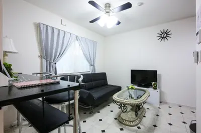 a living room with a black couch and a table at 3, Kameido, Entire house for rent, \u4e80\u6238 in Tokyo