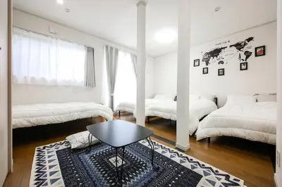 a white bedroom with two beds and a table at 3, Kameido, Entire house for rent, \u4e80\u6238 in Tokyo