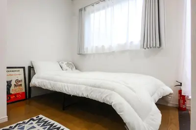 a bedroom with two beds with white sheets and a window at 3, Kameido, Entire house for rent, \u4e80\u6238 in Tokyo