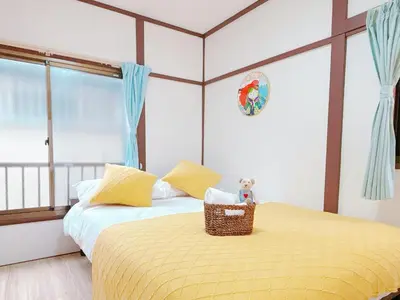 a bedroom with a yellow bed with a basket on it at Ikebukuro area, two layer house, double subway,3 min walk to stn, \u53cc\u5730\u94c1\u8f66\u7ad9\u6b65\u884c3\u5206 \u76f4\u8fbe\u65b0\u5bbf \u6da9\u8c37 \u94f6\u5ea7 \u6c60\u888b \u7687\u5c45 \u6700\u59276\u4eba in Tokyo