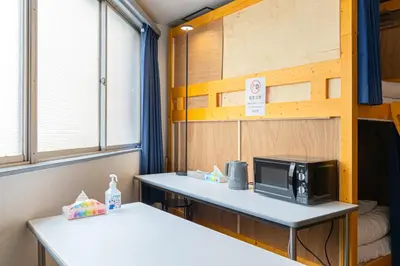 a small room with a microwave on a table at Dormitory Kinshu - \u30c9\u30df\u30c8\u30ea\u30fc\u9326\u7e4d in Tokyo