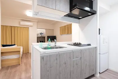 a kitchen with a sink and a refrigerator at \u30a2\u30a4\u30c7\u30a3\u84b2\u7530\u897f in Tokyo