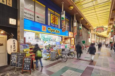 a group of people walking through a shopping mall at \u30a2\u30a4\u30c7\u30a3\u84b2\u7530\u897f in Tokyo